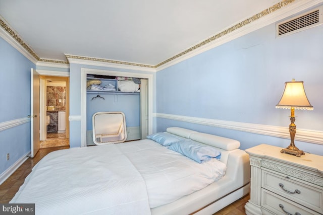 bedroom with crown molding, visible vents, and a closet