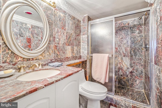 full bath featuring a shower stall, vanity, tile walls, and toilet
