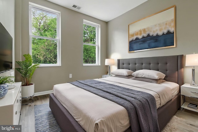 bedroom featuring light wood-style floors and baseboards