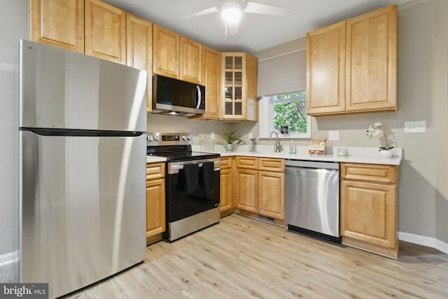 kitchen featuring stainless steel appliances, light countertops, light wood-type flooring, and a ceiling fan