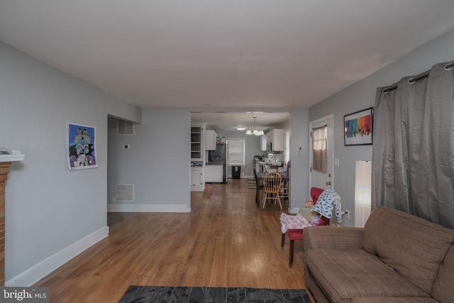 205 Polk Ave, Front Royal, VA 22630 - living area featuring wood finished floors, a chandelier, and baseboards