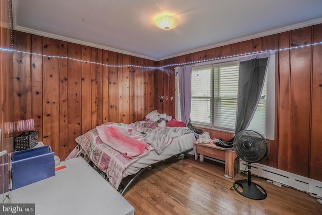 205 Polk Ave, Front Royal, VA 22630 - bedroom with ornamental molding, a baseboard heating unit, wood finished floors, and wood walls