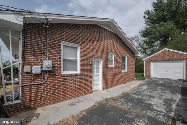 205 Polk Ave, Front Royal, VA 22630 - view of property exterior with an outdoor structure, asphalt driveway, a detached garage, and brick siding