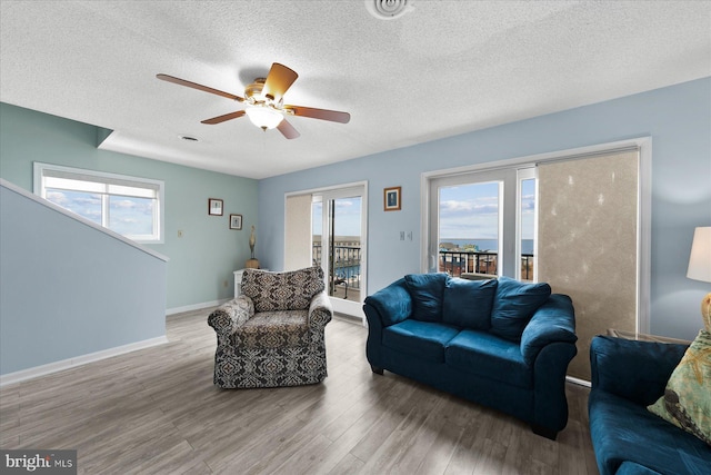 5401 Coastal Hwy Unit 306, Ocean City, MD 21842 - living room with a textured ceiling, baseboards, a ceiling fan, and wood finished floors
