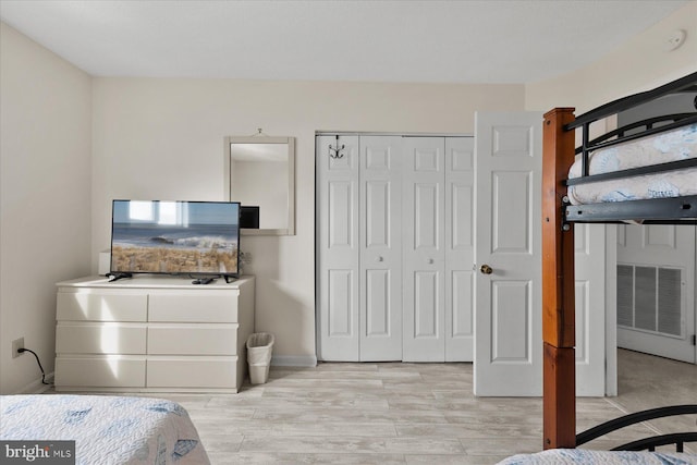 5401 Coastal Hwy Unit 306, Ocean City, MD 21842 - bedroom featuring a closet, baseboards, and light wood-style floors
