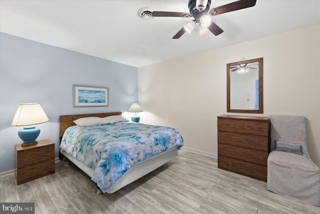 5401 Coastal Hwy Unit 306, Ocean City, MD 21842 - bedroom featuring light wood-style flooring, a ceiling fan, baseboards, and a textured ceiling