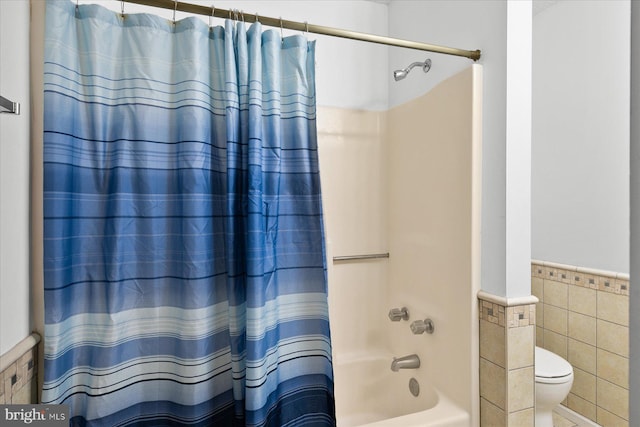 5401 Coastal Hwy Unit 306, Ocean City, MD 21842 - full bath with shower / tub combo with curtain, a wainscoted wall, tile walls, and toilet