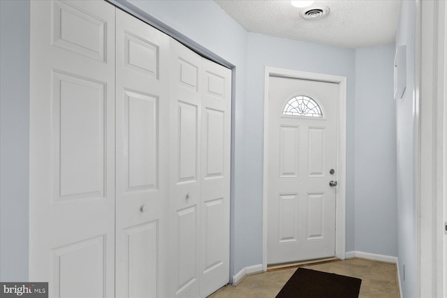 5401 Coastal Hwy Unit 306, Ocean City, MD 21842 - foyer entrance with visible vents, baseboards, light wood finished floors, and a textured ceiling