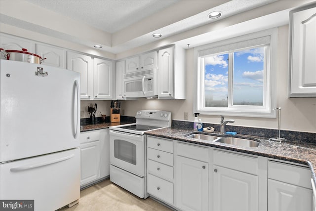 5401 Coastal Hwy Unit 306, Ocean City, MD 21842 - kitchen featuring dark stone countertops, white appliances, a textured ceiling, white cabinets, and a sink