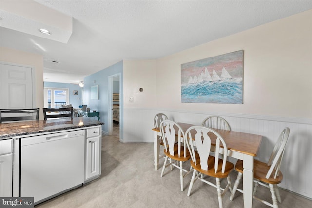 5401 Coastal Hwy Unit 306, Ocean City, MD 21842 - dining space featuring a textured ceiling and a wainscoted wall