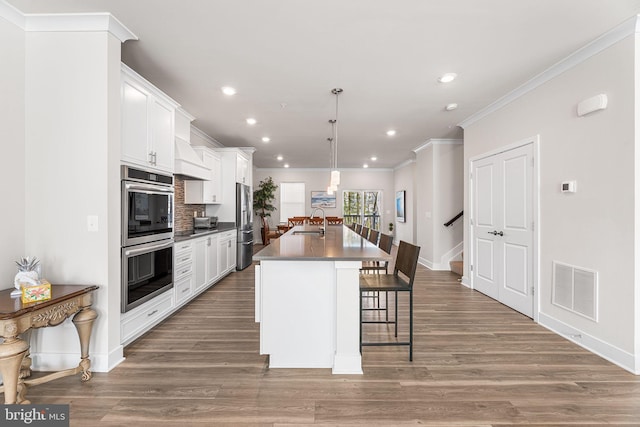 12435 Sea Oaks Ln Unit 3, Berlin, MD 21811 - kitchen featuring an island with sink, visible vents, appliances with stainless steel finishes, a sink, and a breakfast bar area