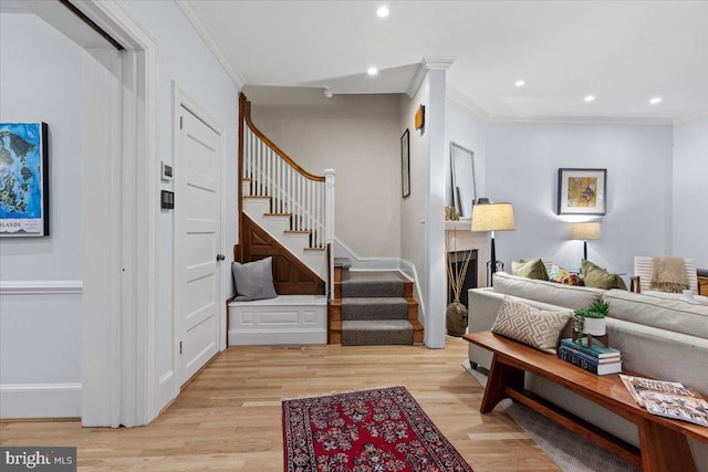 living room featuring ornamental molding, stairs, light wood-type flooring, recessed lighting, and baseboards