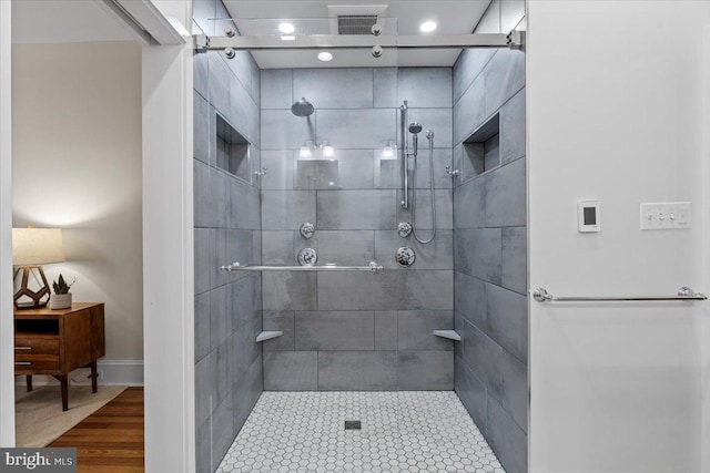 bathroom with a tile shower and recessed lighting