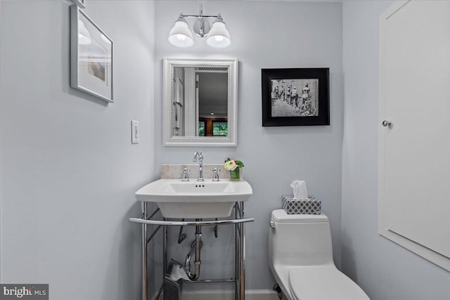 half bathroom featuring toilet and a sink