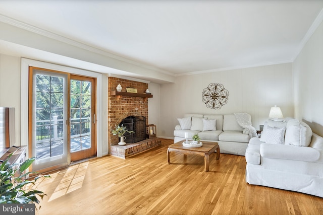 living room with light wood-type flooring, a brick fireplace, and ornamental molding