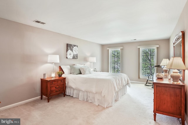 bedroom featuring visible vents, baseboards, and light colored carpet