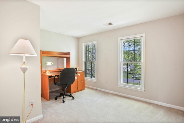 office featuring baseboards, visible vents, and light colored carpet