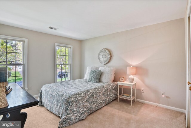carpeted bedroom with visible vents and baseboards