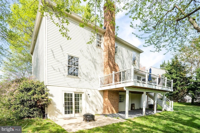 rear view of house featuring a patio area, a lawn, stairs, a deck, and an outdoor fire pit