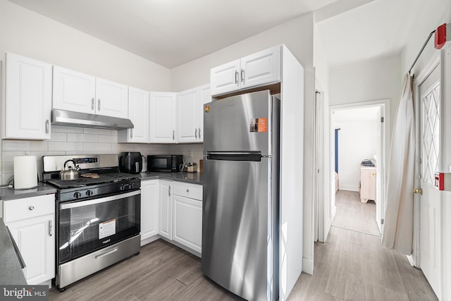 1529 E Berks St, Philadelphia, PA 19125 - kitchen with dark countertops, backsplash, appliances with stainless steel finishes, and under cabinet range hood