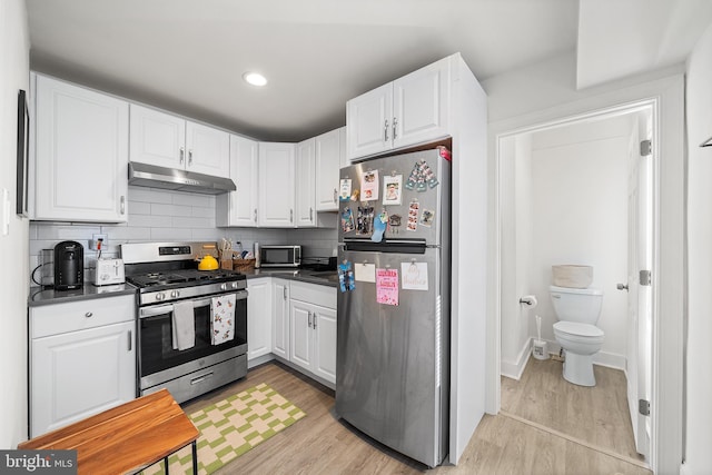 1529 E Berks St, Philadelphia, PA 19125 - kitchen with light wood-style flooring, dark countertops, under cabinet range hood, and stainless steel appliances