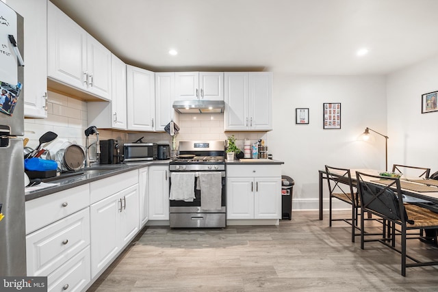 1529 E Berks St, Philadelphia, PA 19125 - kitchen featuring white cabinetry, under cabinet range hood, gas stove, dark countertops, and light wood finished floors