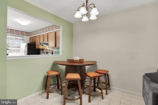 dining room with crown molding, baseboards, and a notable chandelier