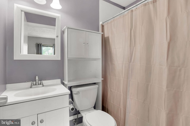 bathroom featuring vanity, toilet, and curtained shower