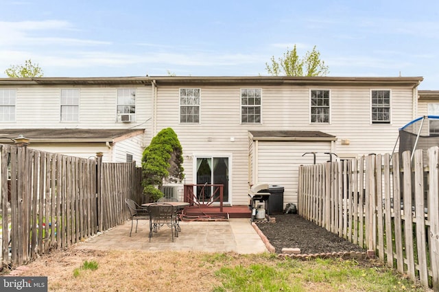 rear view of house featuring a patio and a fenced backyard