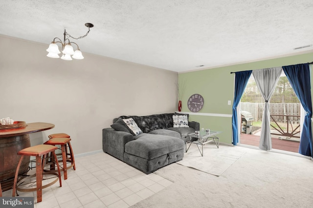 living area featuring a notable chandelier, a textured ceiling, visible vents, and baseboards