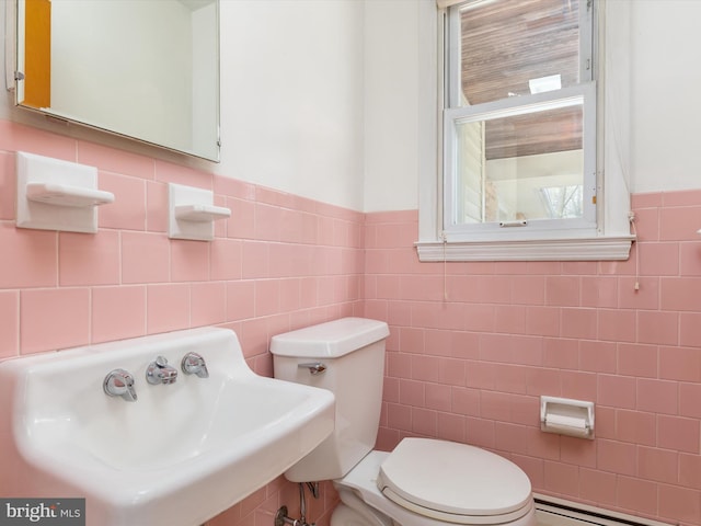 7147 Ohio Ave, Hanover, MD 21076 - bathroom with a baseboard heating unit, toilet, wainscoting, tile walls, and a sink
