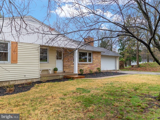7147 Ohio Ave, Hanover, MD 21076 - view of front facade with a chimney, stone siding, an attached garage, aphalt driveway, and a front yard