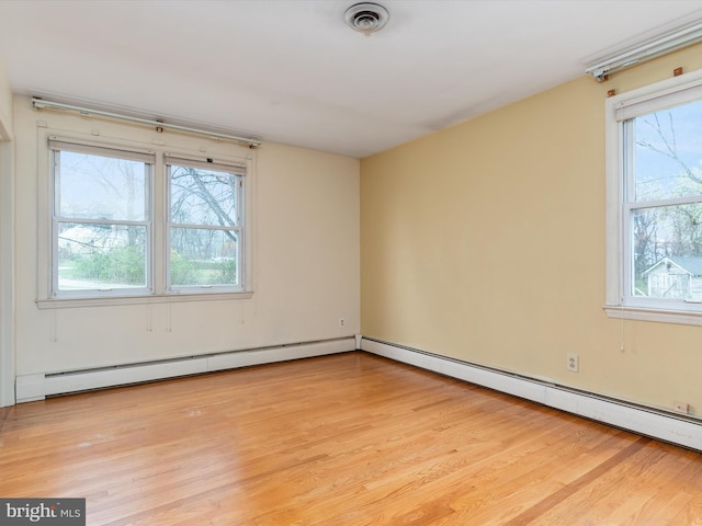 7147 Ohio Ave, Hanover, MD 21076 - empty room with plenty of natural light, light wood finished floors, visible vents, and a baseboard heating unit