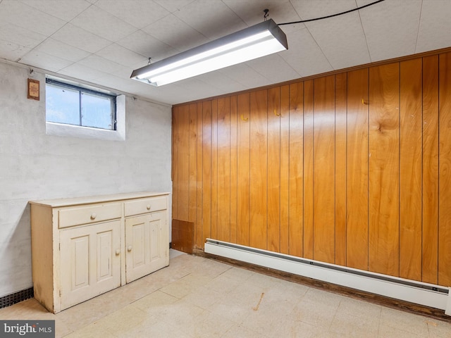 7147 Ohio Ave, Hanover, MD 21076 - below grade area with wood walls, a baseboard heating unit, and light floors