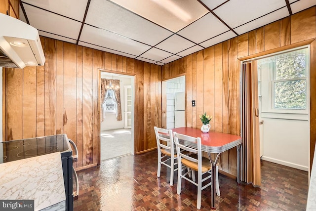 1233 Kahler Ave, Rosedale, MD 21237 - dining room featuring a paneled ceiling, wooden walls, and baseboards