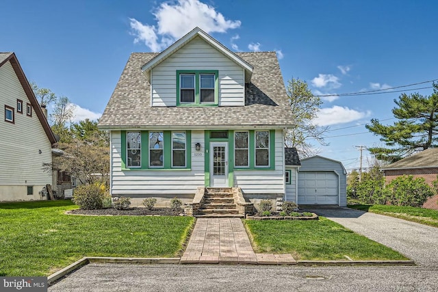 1233 Kahler Ave, Rosedale, MD 21237 - bungalow featuring an outbuilding, a detached garage, a front yard, a shingled roof, and driveway