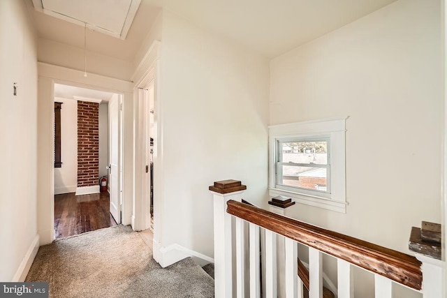 1233 Kahler Ave, Rosedale, MD 21237 - hallway featuring baseboards, brick wall, an upstairs landing, attic access, and carpet flooring