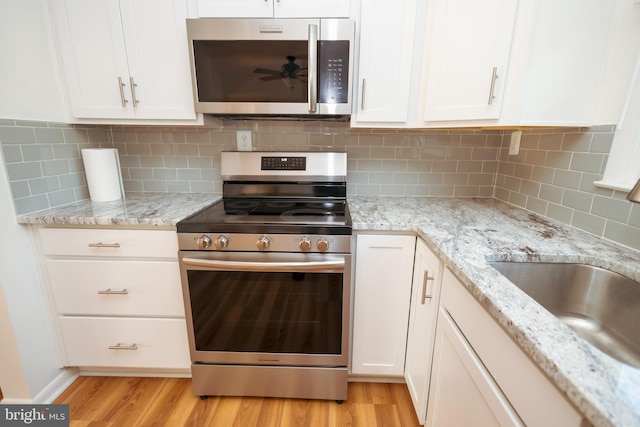 4513 Baker Valley Rd, Frederick, MD 21704 - kitchen featuring stainless steel appliances, light wood-style floors, white cabinets, and a sink