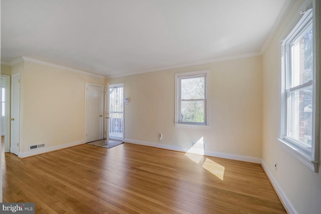 empty room with plenty of natural light, baseboards, ornamental molding, and light wood-type flooring