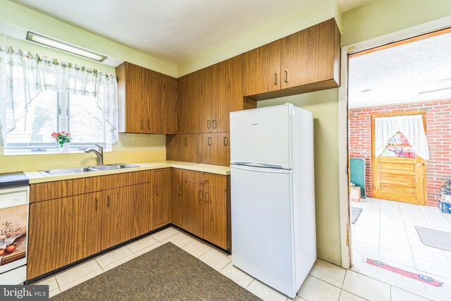 8549 Marybeth Way, Ellicott City, MD 21043 - kitchen featuring a sink, brown cabinetry, white appliances, light countertops, and light tile patterned floors