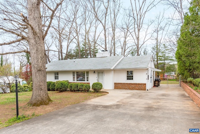 view of front of property with concrete driveway and a chimney