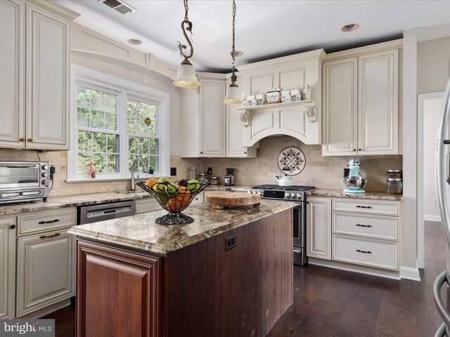 kitchen with stainless steel range with gas cooktop, backsplash, dark wood-style floors, and light stone countertops