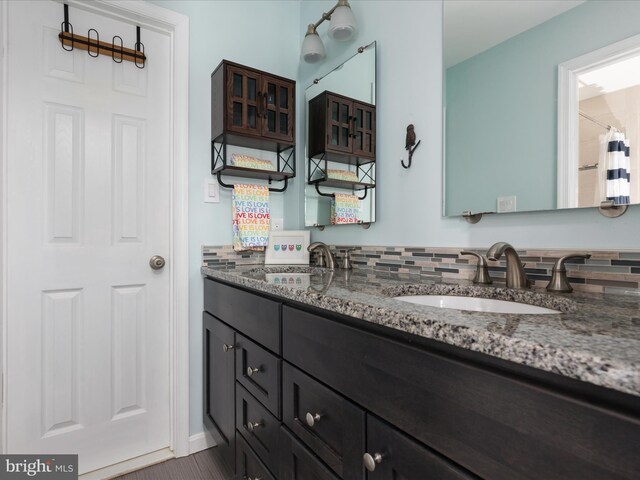 full bathroom featuring double vanity and a sink