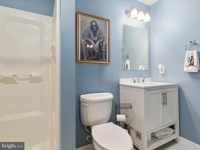 bathroom with vanity, baseboards, toilet, and a shower