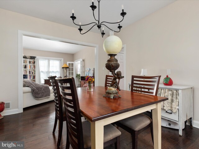 dining room featuring visible vents, dark wood finished floors, baseboards, and a notable chandelier