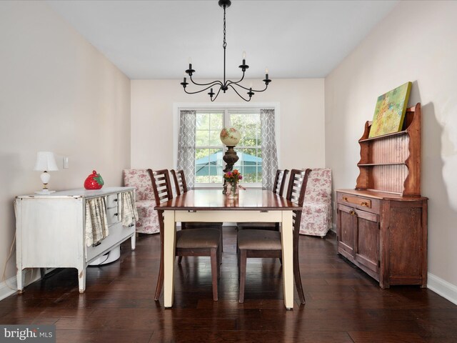 dining area with baseboards, dark wood-type flooring, and a chandelier