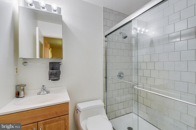 bathroom featuring vanity, a stall shower, and toilet