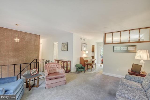 living room with baseboards, a notable chandelier, carpet, and brick wall