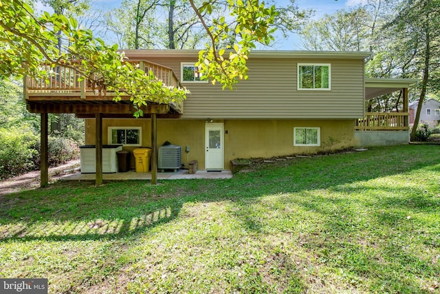 rear view of house featuring a lawn, a wooden deck, and central AC unit