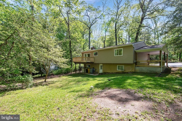 rear view of house featuring a lawn, a chimney, and a deck